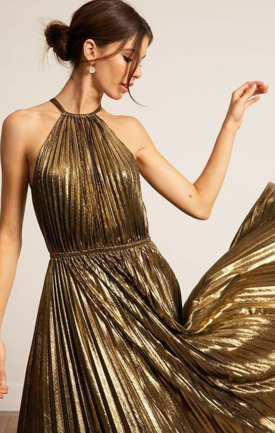 Woman in gold halter neck dress.