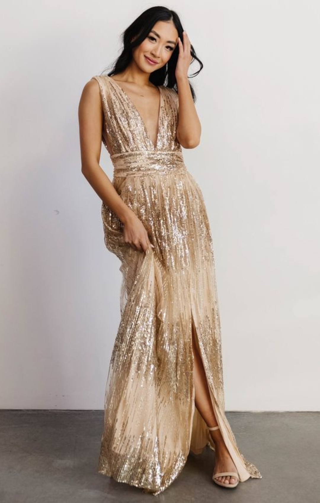 Woman in long, flowy, champagne colored dress with v-neck top.