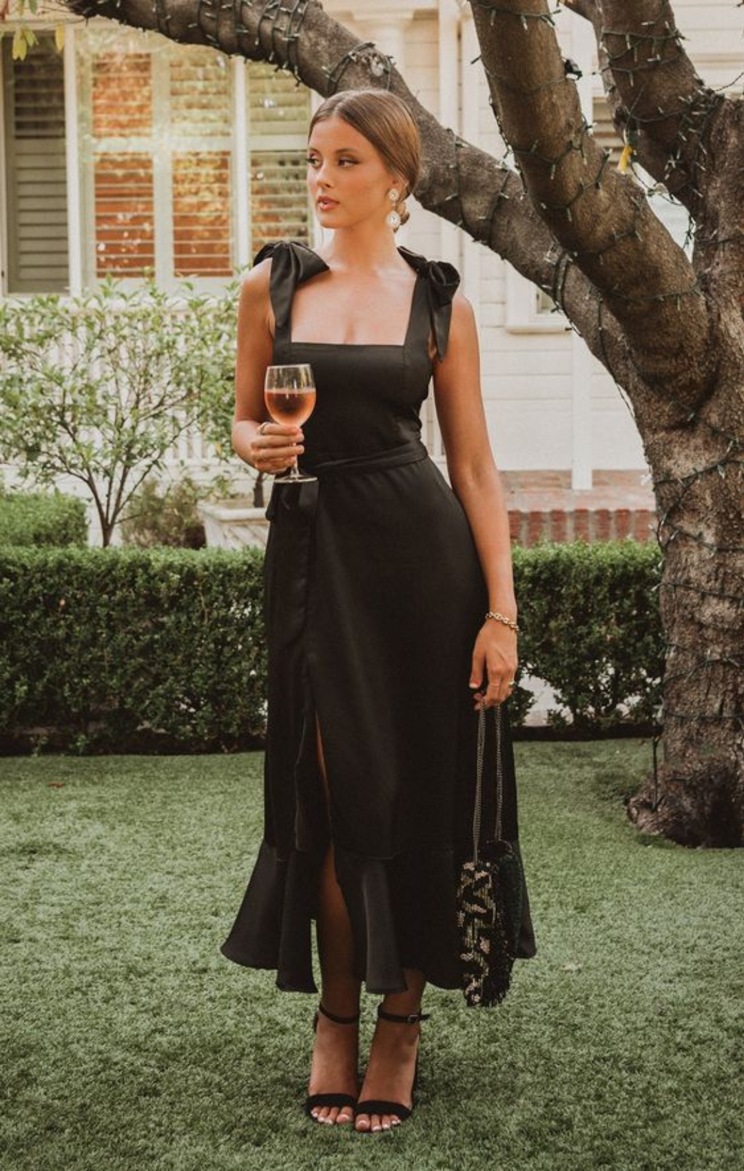 Woman in long, black, square neck dress with tank top sleeves.