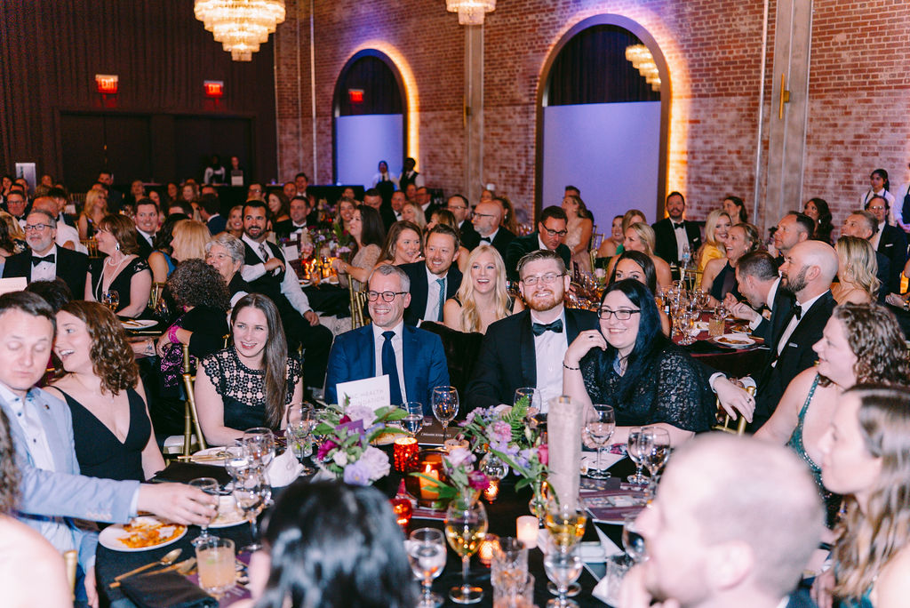 Crowd cheering at formal gala.